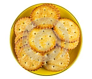 Round crackers in yellow saucer isolated on white. Top view
