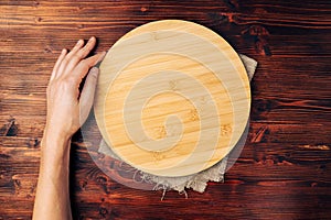 Round cutting board on a wooden kitchen table. Free space for your decoration