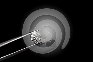 Round diamond.Black and white photo.Organized by tweezers. Lights on the diamond.Focus on diamonds. Heart shadow