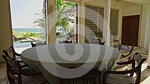 Round dining table in luxury retro villa on tropical island with blue ocean and palm trees views. Place for breakfast