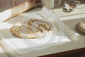 Round dough on a table, preparing ramadan pide with sesame seeds