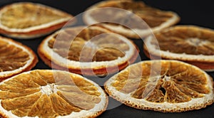 round dried slices of natural orange on a black background as a background, low depth of field