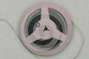 Round film reel. Gray bobbin close-up. The concept of watching an old movie. Family archive