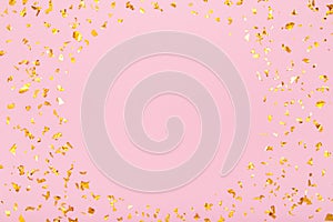 Round frame of golden glitter confetti sparkles on pastel pink background. Flat lay, top view. Holiday, festive, party