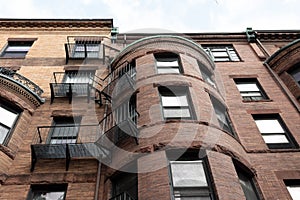 Round front of brownstone city housing, rusticated stone trim and metal balconies