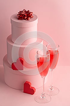 Round gift boxes, red hearts and glasses of sparkling wine