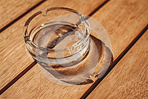 Round glass ashtray in sunny natural light by the window on a table in a cafe