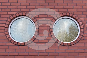 Round glass windows of a brick-walled building