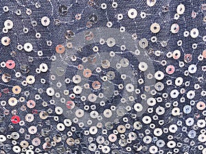Round glitter silver sequin on blue lace fabric