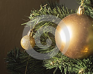 Round golden toy on the Christmas tree weighs