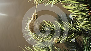 Round golden toy on the Christmas tree weighs