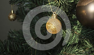 Round golden toy on the Christmas tree weighs