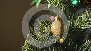 Round golden toy on the Christmas tree weighs