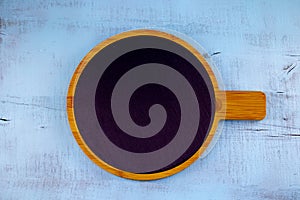 Round graphite cutting cooking Board on wooden surface