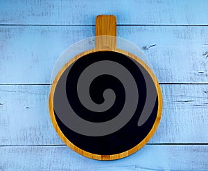 Round graphite cutting cooking Board on wooden surface