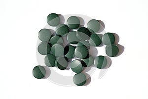 Round green pills on a white background top view.