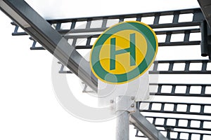 Round green and yellow bus stop sign with the letter H in germany