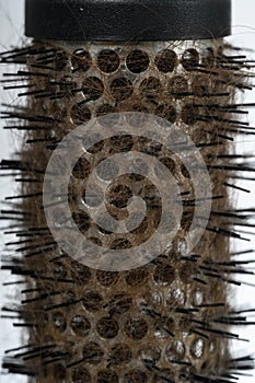 round hair brush with fallen hair, highlighted on a white background, close-up, vertical frame