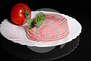 Round ham. Sliced pink ham meat on black reflective studio background. Isolated black shiny mirror mirrored background for every c