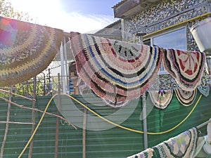Round handmade folk mats dry in the yard