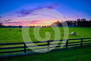 Round Hay Bails in a Field With Fence