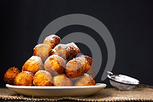 Round homemade donuts in a plate on a wooden table