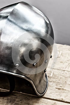 Round iron helmet protection of the medieval warrior close-up stands on the table