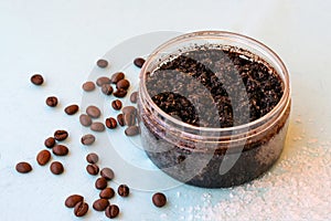 Round jar full of coffee scrub with roasted beans and sea salt as homemade facial and body exfoliation treatment