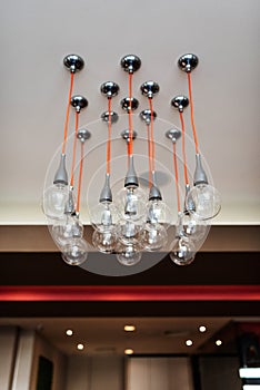 Round lamps on red long cords, conceptual chandelier