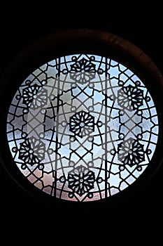 Round leaded glass window with floral medallions and six-point stars