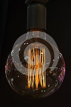 Round lit bulb with filaments, dark background photo