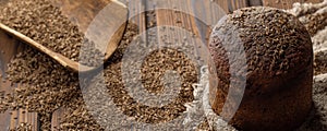 Round loaf of rye bread with thyme on rustic style wooden table.