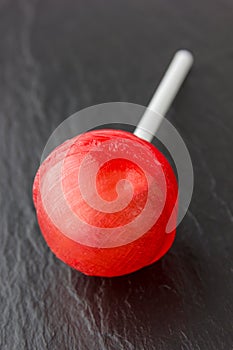 Round lollipop on a stick of red color.