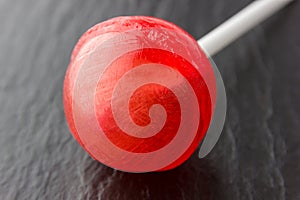 Round lollipop on a stick of red color.