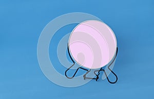 Round make up mirror on a blue background. screen for inserting any reflection and image