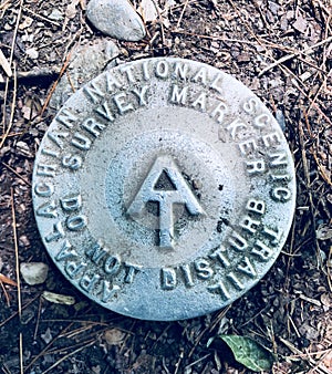 A round metal marker of Appalachian Trail