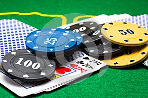 Round multi colored poker chips lie on a deck of cards