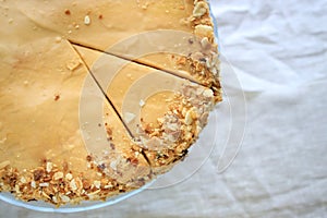 round napoleon cake, with caramel cream and a cut off piece, on a white background. copy space