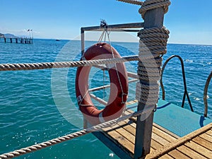 Round non-sinking red lifebuoy for safety to save the lives of drowning people tourists against the background of the sea in a