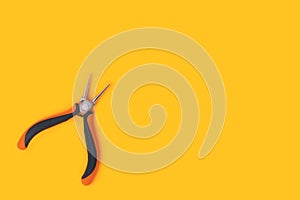 Round-nose pliers on a yellow background.