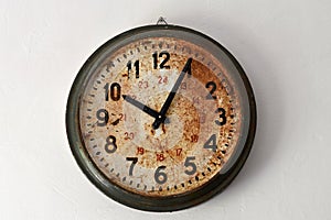 Round old clock with rust on clock face. Arabic numerals