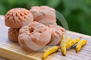 Round orange soap in the form of flowers with turmeric on a green background