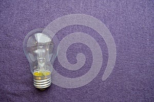 A round, ordinary, non-economical incandescent bulb with a transparent socle