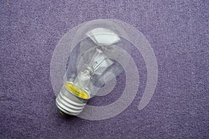 A round, ordinary, non-economical incandescent bulb with a transparent socle