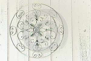 Round ornate metal medallion hanging on wooden wall