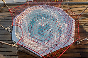 Round outdoor Jacuzzi in a cruise ship is covered with a net