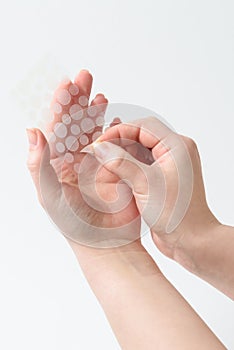 Round patches for acne and wrinkles on the hands on a white background. Acne and wrinkle patches for facial rejuvenation