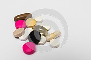 Round pills and oval hard and soft capsules on white background