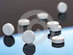 Round pills with risks are reflected in a mirror surface. Medical background for business, industry, pharmacies, clinics photo