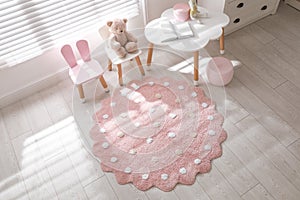 Round pink rug on floor in children`s room